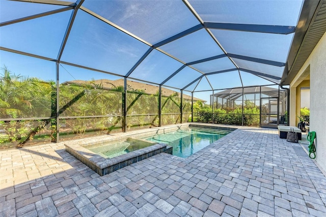 view of swimming pool featuring a lanai, an in ground hot tub, and a patio