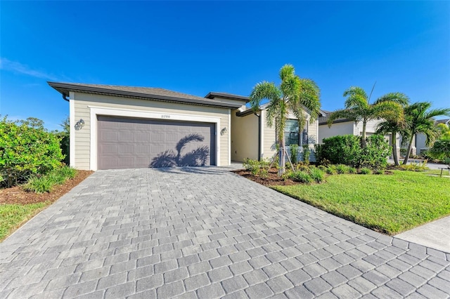 single story home featuring a garage and a front yard