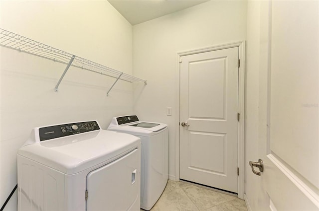 washroom featuring washer and clothes dryer and light tile patterned flooring