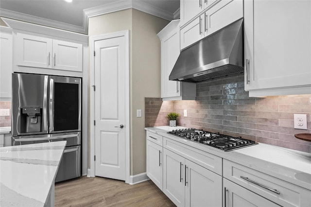 kitchen featuring crown molding, light hardwood / wood-style floors, light stone counters, white cabinetry, and stainless steel appliances