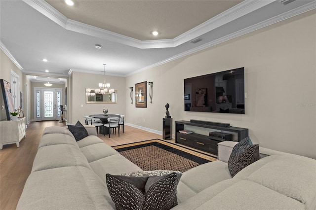 living room featuring a chandelier, hardwood / wood-style floors, french doors, and crown molding