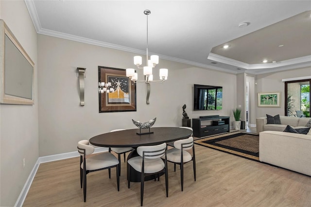 dining area featuring light hardwood / wood-style flooring, a notable chandelier, and ornamental molding