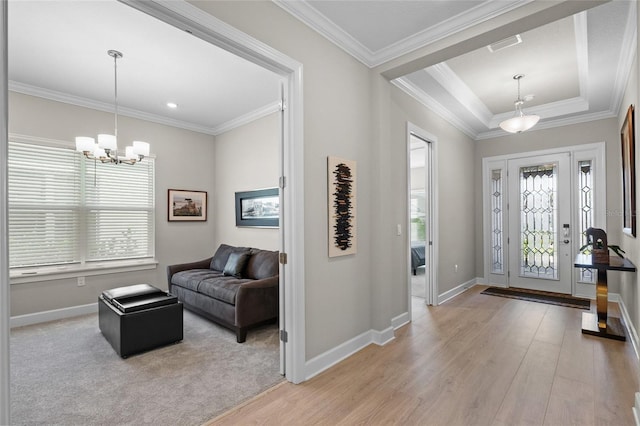 entrance foyer featuring light wood-type flooring, crown molding, and an inviting chandelier