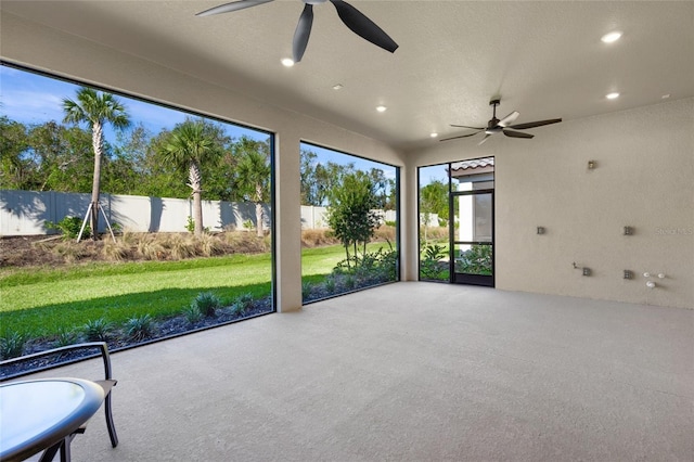 unfurnished sunroom with ceiling fan