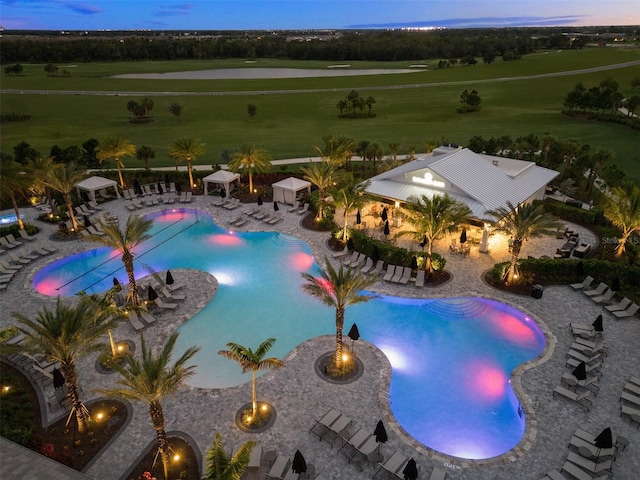 pool at dusk with a patio