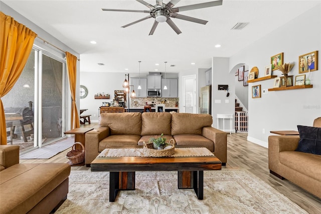 living room with light hardwood / wood-style flooring and ceiling fan