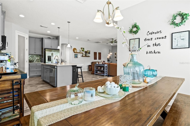 dining area featuring dark hardwood / wood-style floors and ceiling fan with notable chandelier