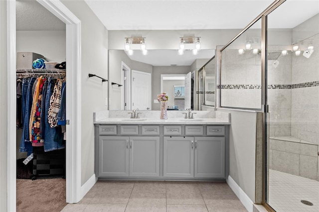 bathroom featuring tile patterned floors, vanity, and a shower with shower door