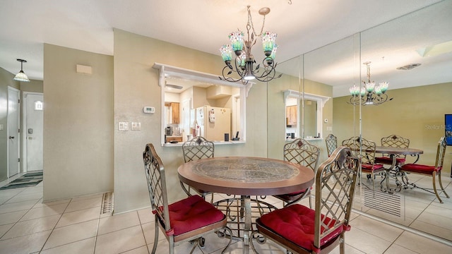 dining space with a notable chandelier and light tile patterned floors