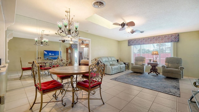 tiled dining area featuring a textured ceiling, a skylight, and ceiling fan