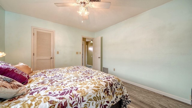 bedroom featuring hardwood / wood-style flooring, ceiling fan, and a closet