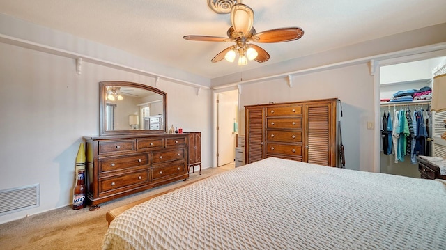 carpeted bedroom featuring ceiling fan and a closet