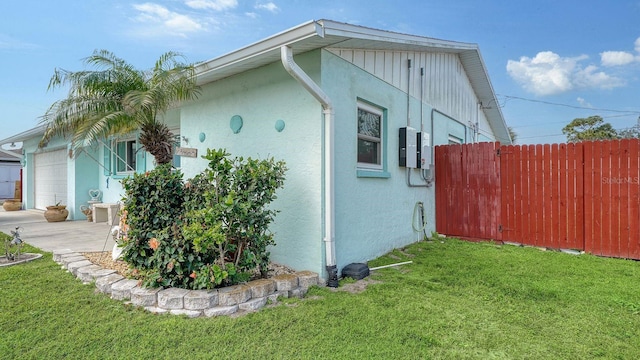 view of side of home with a garage and a lawn