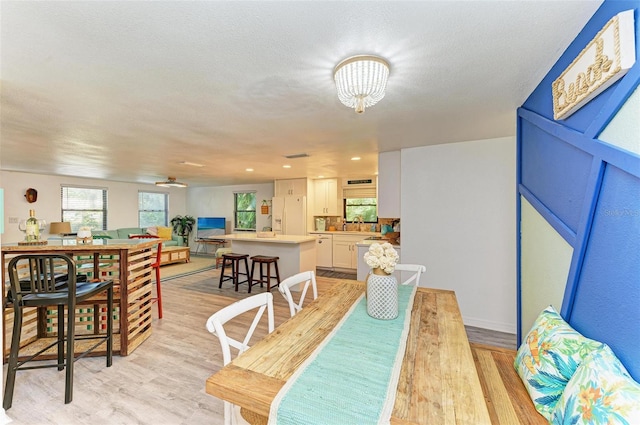 dining space with light hardwood / wood-style flooring and a textured ceiling