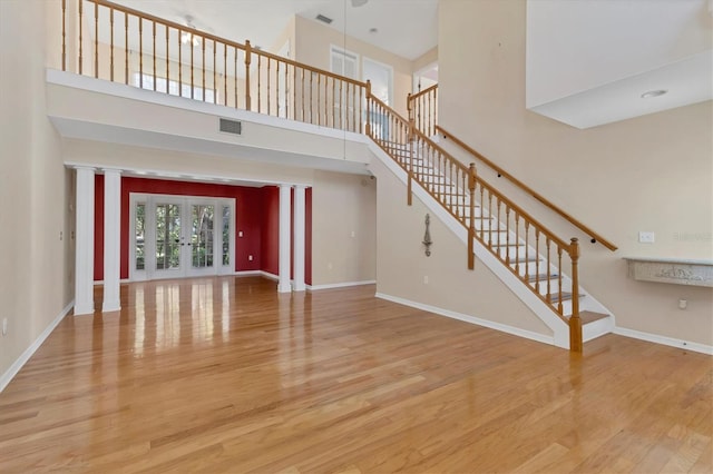 unfurnished living room with french doors, a high ceiling, and hardwood / wood-style flooring