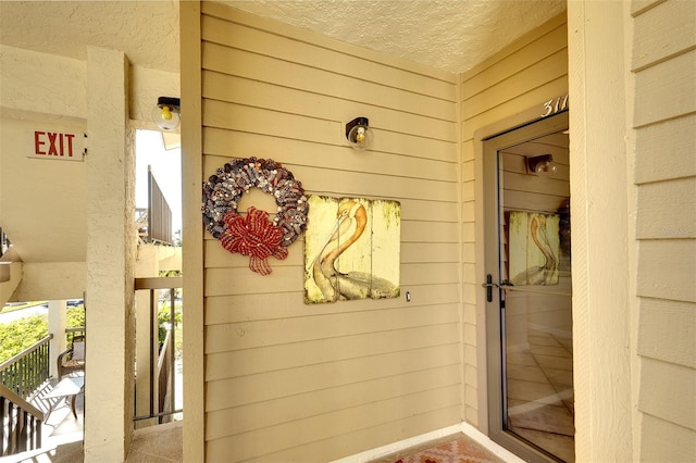 exterior space featuring a textured ceiling and wooden walls