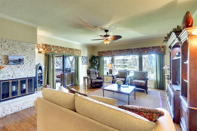 living room with hardwood / wood-style floors, plenty of natural light, ceiling fan, and ornamental molding