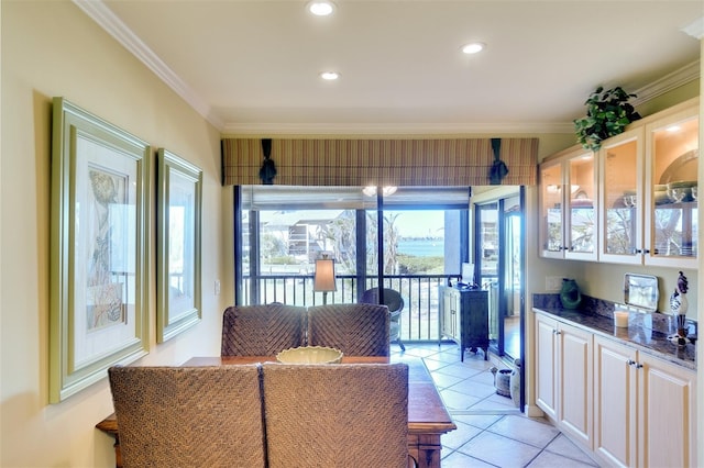 tiled dining area featuring crown molding