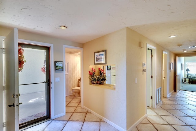 hall featuring light tile patterned floors