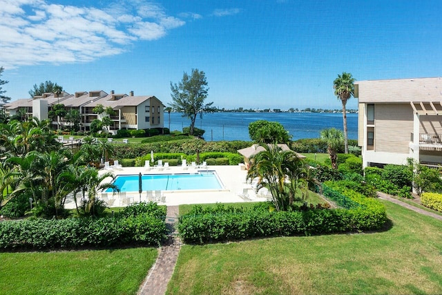 view of pool featuring a water view and a yard