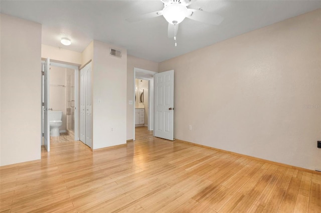 unfurnished bedroom with ceiling fan, connected bathroom, and light wood-type flooring