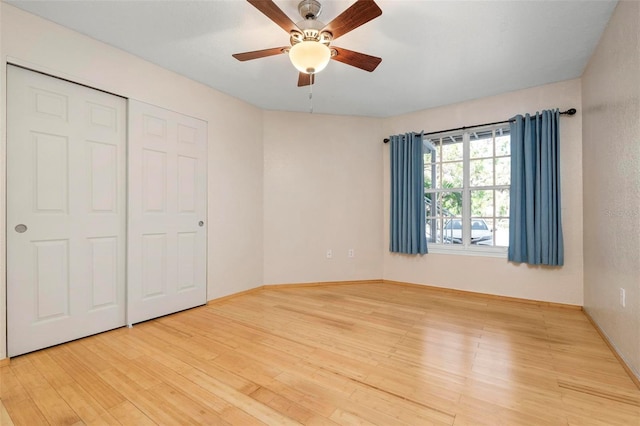 unfurnished bedroom with light wood-type flooring, ceiling fan, and a closet