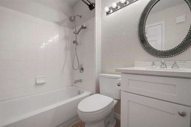 full bathroom with vanity, tiled shower / bath, and toilet