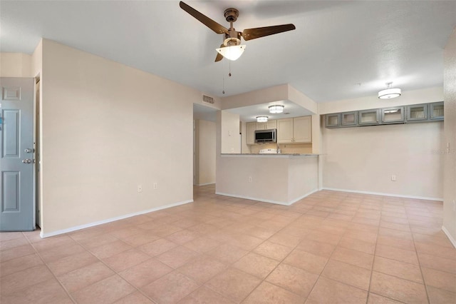 unfurnished living room with ceiling fan and light tile patterned flooring