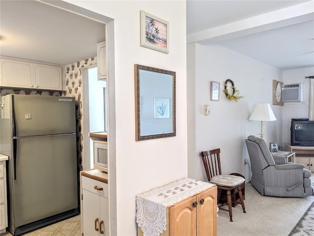 2228 Canal Dr Unit D26, Bradenton, FL 34207 - kitchen featuring freestanding refrigerator, an AC wall unit, light countertops, open floor plan, and stainless steel microwave