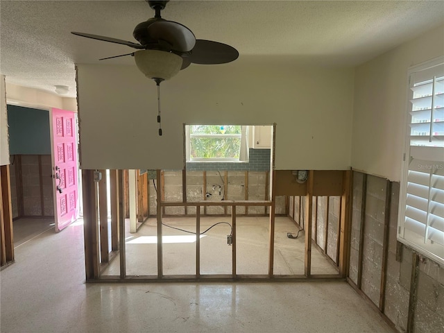 miscellaneous room with a textured ceiling and ceiling fan