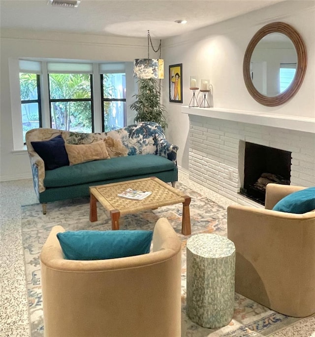 carpeted living room featuring a chandelier and a brick fireplace