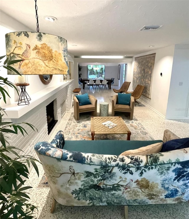 living room featuring carpet floors, a textured ceiling, and a brick fireplace