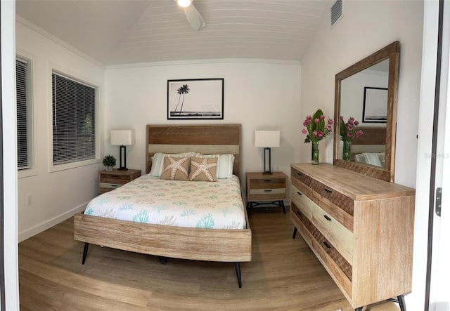 bedroom with light hardwood / wood-style flooring, vaulted ceiling, and ceiling fan