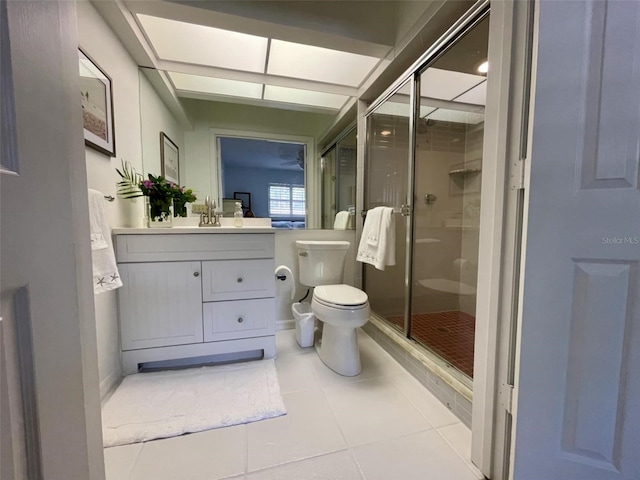 bathroom with toilet, a shower with door, vanity, and tile patterned flooring