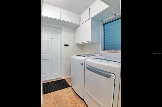 laundry room featuring washer and dryer, cabinets, and light tile patterned floors