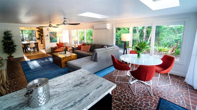 living room with ceiling fan, an AC wall unit, and a skylight