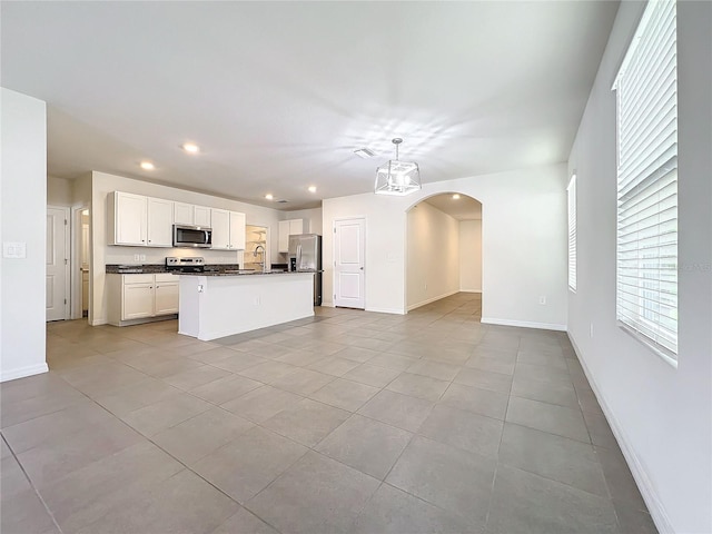 kitchen with a kitchen island with sink, sink, appliances with stainless steel finishes, decorative light fixtures, and white cabinetry