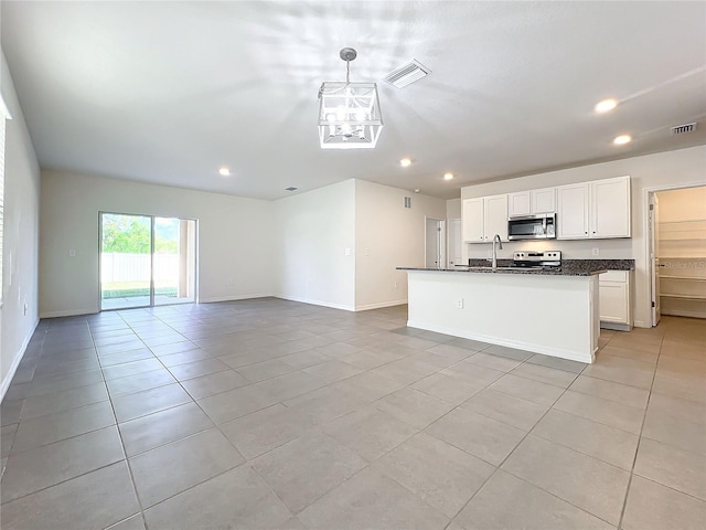 kitchen featuring light tile patterned floors, decorative light fixtures, a kitchen island with sink, white cabinets, and appliances with stainless steel finishes