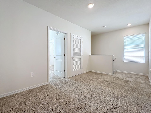 spare room featuring light colored carpet