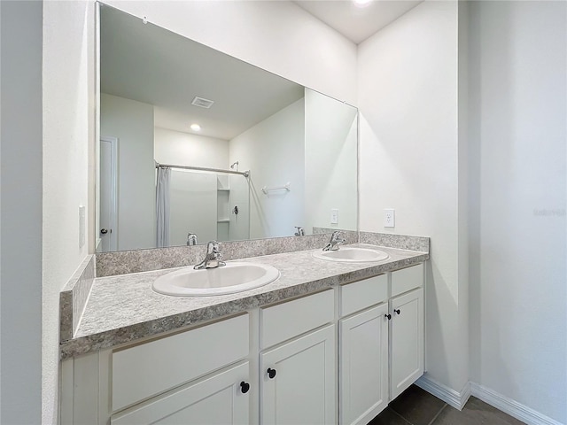 bathroom with tile patterned flooring, vanity, and walk in shower