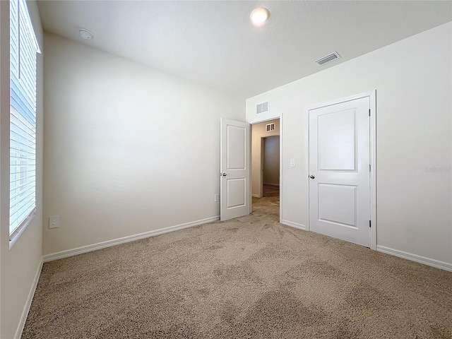 spare room featuring light carpet