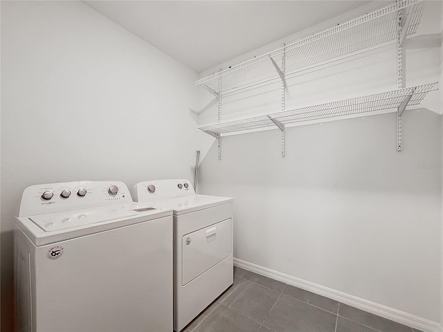 clothes washing area with washer and dryer and dark tile patterned floors