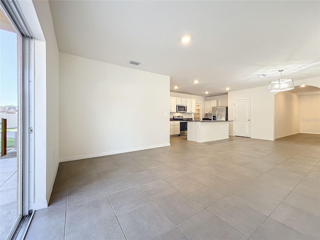 unfurnished living room with a healthy amount of sunlight and light tile patterned floors