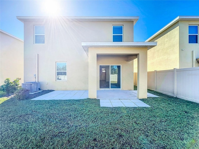 back of house featuring a patio area and a lawn