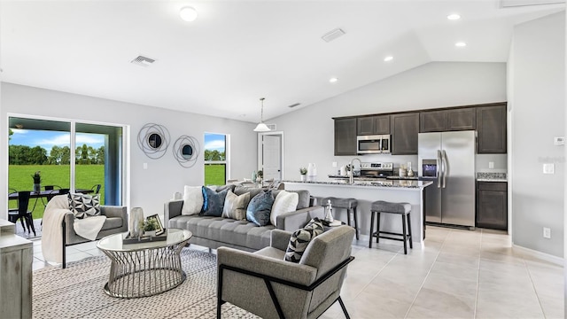 tiled living room featuring a wealth of natural light, lofted ceiling, and sink