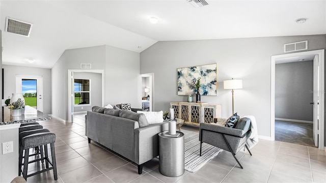 living room with tile patterned flooring and vaulted ceiling