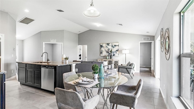 dining space with plenty of natural light, light tile patterned floors, vaulted ceiling, and sink