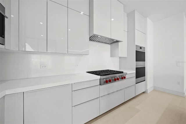 kitchen with white cabinetry, custom range hood, and appliances with stainless steel finishes