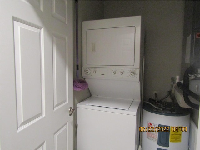 laundry room featuring water heater and stacked washer and clothes dryer