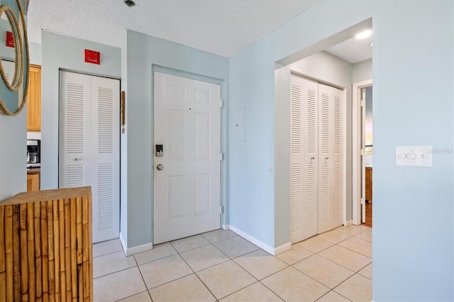 tiled foyer entrance with a textured ceiling